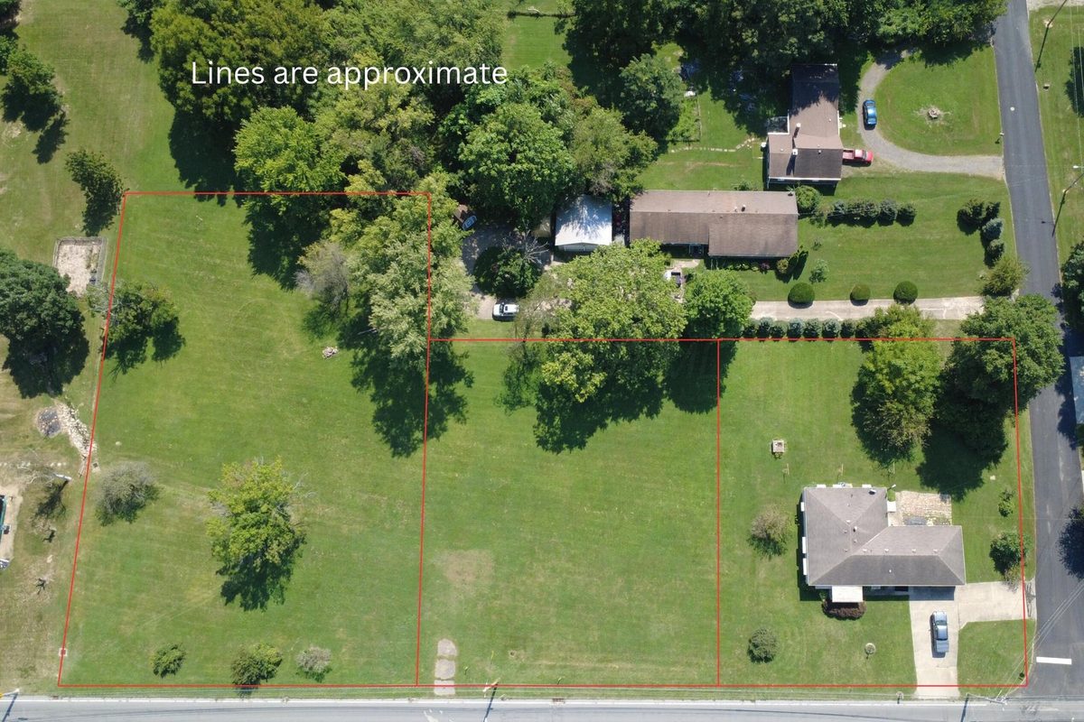 Aerial view of the 0 W Fair Avenue lots in Lancaster, Ohio, open grass lots with trees, the lot lines drawn in red and marked as approximate