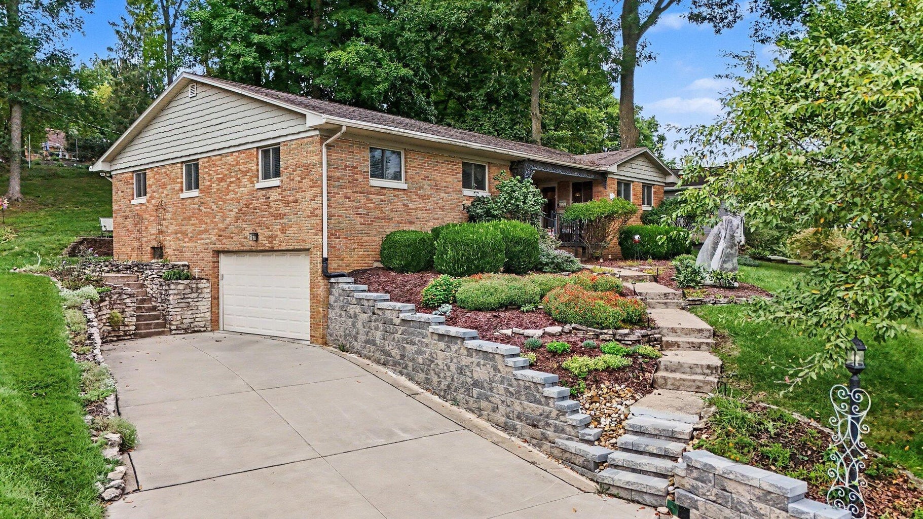 Exterior of 385 Kemper Avenue, Lancaster, Ohio, a brick ranch home with attached garage and terraced landscaping