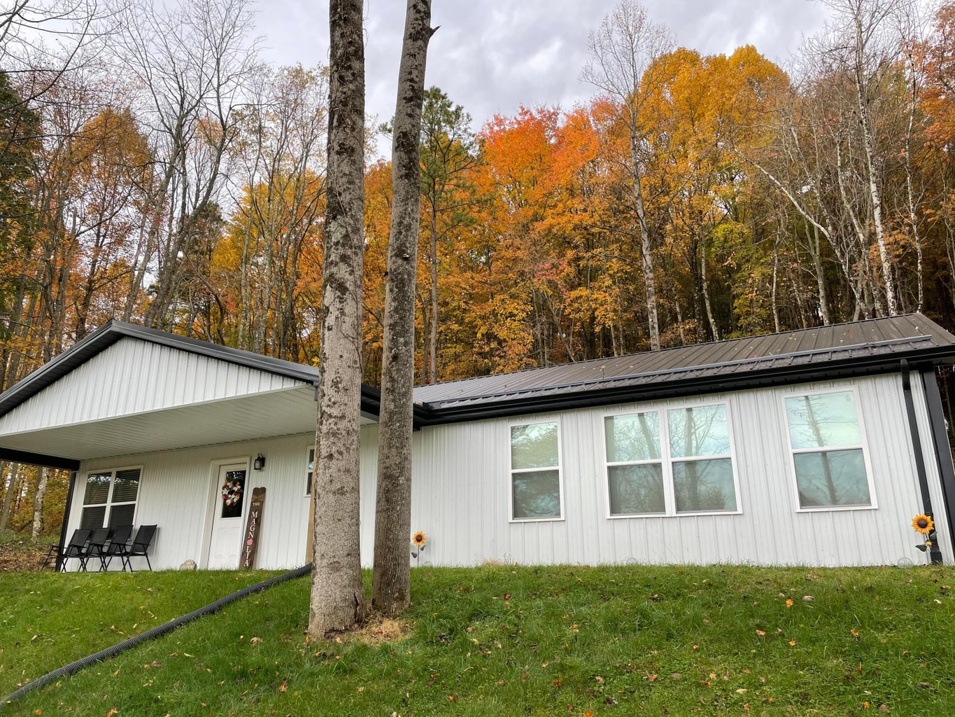 Exterior of 813 Eaton Hollow Road SW, Lancaster, Ohio, a white ranch home with a covered porch surrounded by fall trees